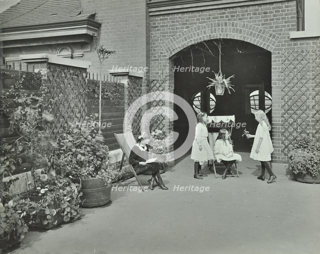 Girls relaxing in a roof top garden, White Lion Street School, London, 1912. Artist: Unknown.