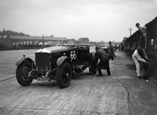 GL Baker's 5954 cc Minerva undergoing a rear wheel change at Brooklands. Artist: Bill Brunell
