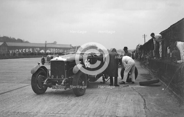 GL Baker's 5954 cc Minerva undergoing a rear wheel change at Brooklands. Artist: Bill Brunell.