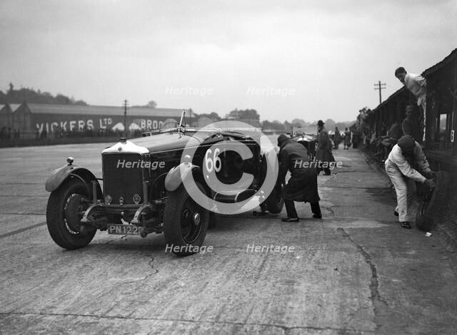 GL Baker's 5954 cc Minerva undergoing a rear wheel change at Brooklands. Artist: Bill Brunell.