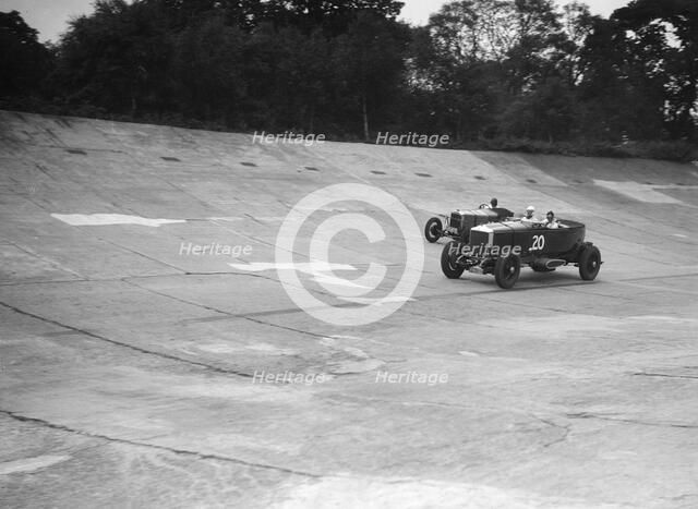 GL Baker's 5954 cc Minerva racing a 1930 Frazer-Nash Sportop on the banking at Brooklands. Artist: Bill Brunell.