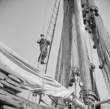 Gloucester fisherman standing in the rigging of a New England fishing boat, New York, 1943. Creator: Gordon Parks