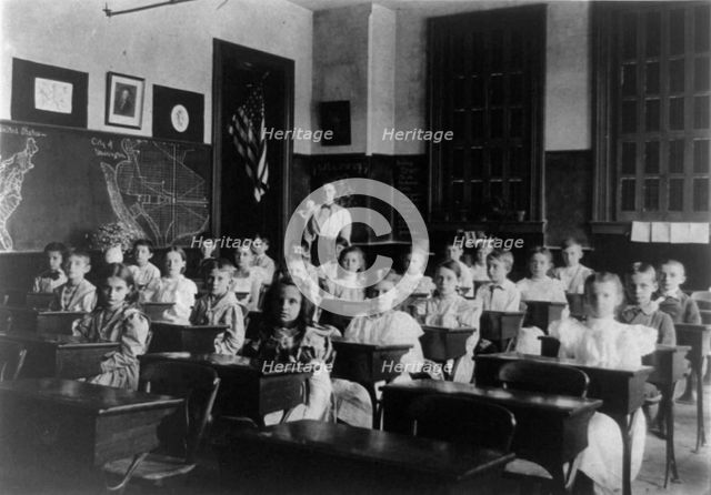 Grade school children posed in classroom, with teacher standing in back..., Washington DC, (1899?). Creator: Frances Benjamin Johnston.