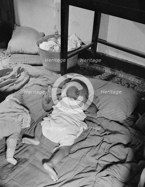 Grandchild of Mrs. Ella Watson, a government charwoman, taking her...nap, Washington, D.C., 1942. Creator: Gordon Parks.