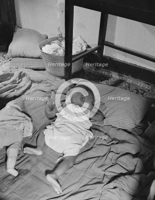 Grandchild of Mrs. Ella Watson, a government charwoman, taking her...nap, Washington, D.C., 1942. Creator: Gordon Parks.