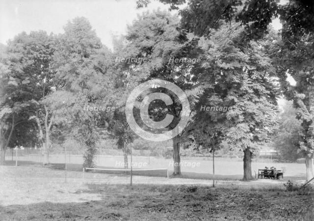 Grass tennis court among trees, c1935. Creator: Kirk & Sons of Cowes.