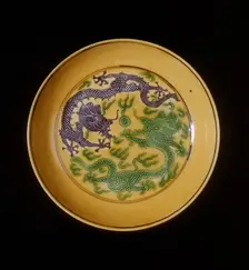 Green and aubergine dragons on yellow ground saucer, Guangxu period, Qing dynasty, China, 1875-1908. Creator: Unknown