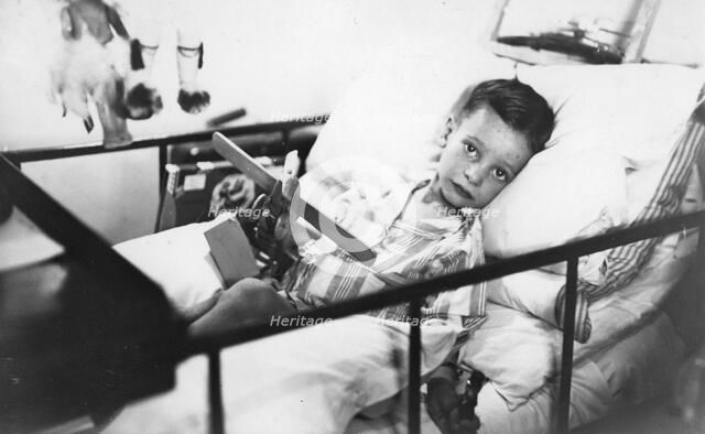 Greek boy from Pylos being nursed in the sick bay of the British battleship HMS 'Malaya', 1938. Artist: Unknown