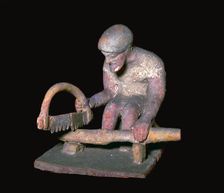 Greek terracotta figure of a man sawing wood, 6th century BC