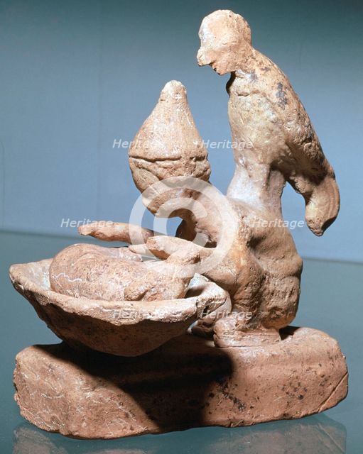 Greek terracotta of a haruspex inspecting pig's entrails. Artist: Unknown