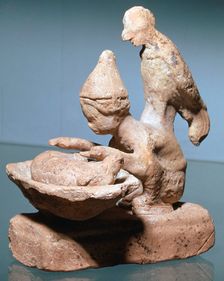 Greek terracotta of a haruspex inspecting pig's entrails