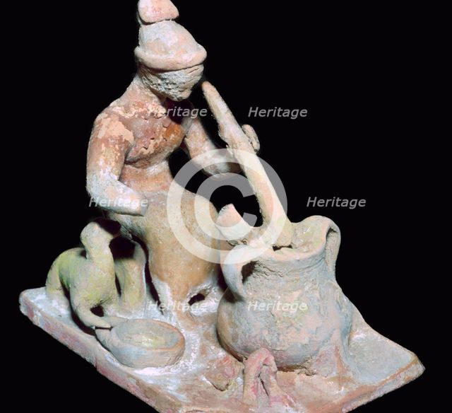 Greek terracotta statuette of a woman cooking. Artist: Unknown