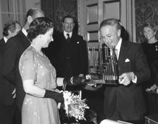 Greville Janner presents the Queen with a menorah, December 1982. Creator: Sidney Harris