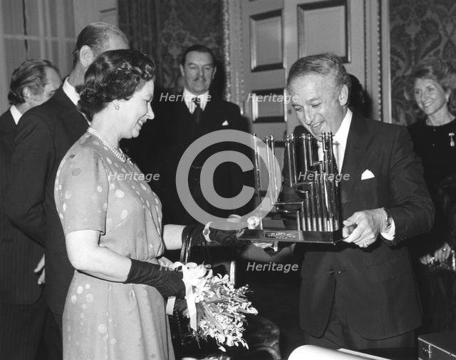 Greville Janner presents the Queen with a menorah, December 1982. Creator: Sidney Harris.