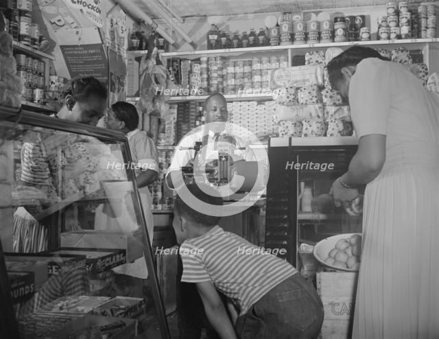 Grocery store owned by Mr. J. Benjamin, on Saturday afternoon, Washington, D.C., 1942. Creator: Gordon Parks.