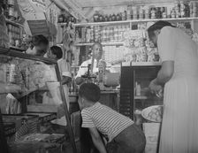 Grocery store owned by Mr. J. Benjamin, on Saturday afternoon, Washington, D.C., 1942. Creator: Gordon Parks