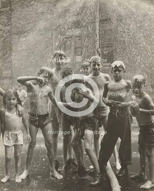 Group of children, mostly boys, gathered under sprinkler, in East Harlem, New York City, 1947 - 1951 Creator: Romulo Lachatanere.