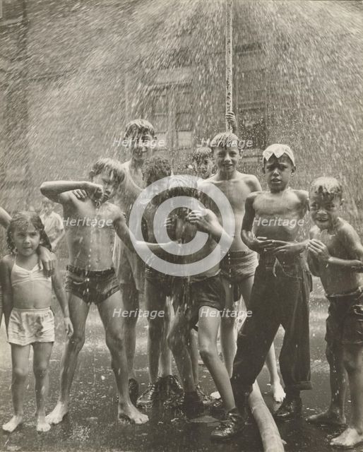 Group of children, mostly boys, gathered under sprinkler, in East Harlem, New York City, 1947 - 1951 Creator: Romulo Lachatanere.