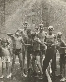 Group of children, mostly boys, gathered under sprinkler, in East Harlem, New York City, 1947 - 1951 Creator: Romulo Lachatanere