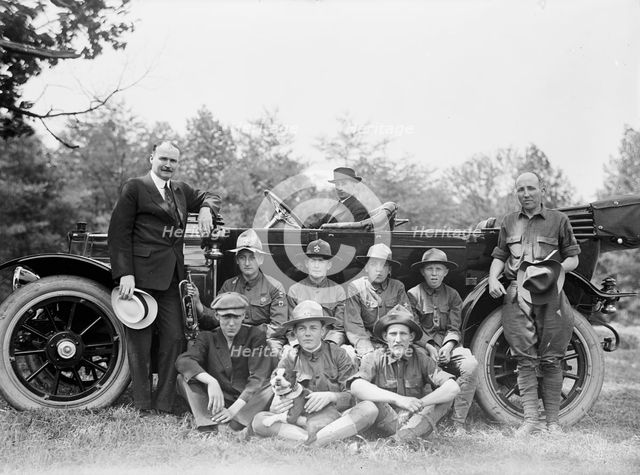 Group of Boy Scouts Posed with Dog And Three Men in Front of An Automobile, between 1914 and 1917. Creator: Harris & Ewing.