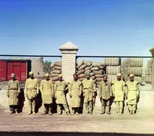 Group of labourers in front of a chain-link fence, between 1905-1915. Creator: Sergey Mikhaylovich Prokudin-Gorsky
