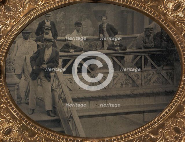 Group of Men and Boys Standing Along the Railing of the Fulton Street Bridge, 1866-68. Creator: Unknown.