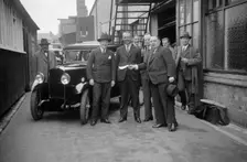 Group of men with a Triumph Super Seven, c1930(?). Artist: Bill Brunell