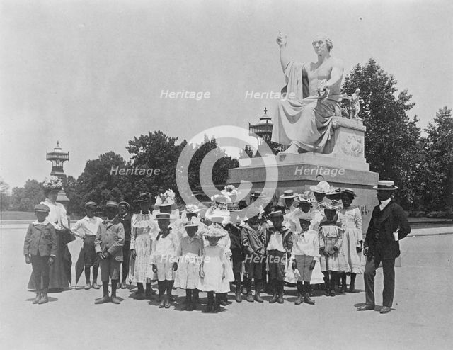 Group of school children in front of statue of George Washington, Washington, D.C., (1899?). Creator: Frances Benjamin Johnston.