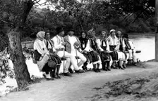 Group of people seated on a bench, Bistrita Valley, Moldavia, north-east Romania, c1920-c1945. Artist: Adolph Chevalier