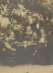 Group portrait around table, 1880-1890. Creator: Victor Dix