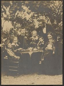 Group portrait around table, 1880-1890. Creator: Victor Dix