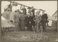 Group portrait in front of plane, 1915-1930. Creator: Fédèle Azari