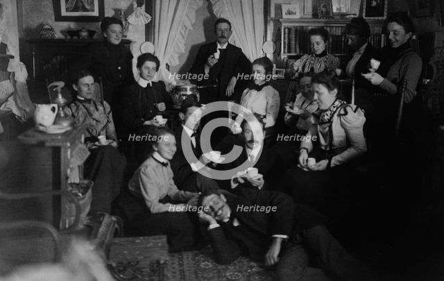 Group portrait of friends at social gathering, seated and standing with tea cups..., c1890 - 1910. Creator: Frances Benjamin Johnston.
