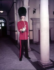 Guards officer in full dress uniform with bearskin on and sword drawn, London, Creator: Arthur Charles Kirby Ware