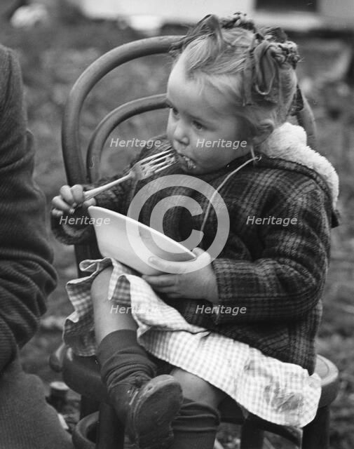 Gypsy girl eating, 1960s.