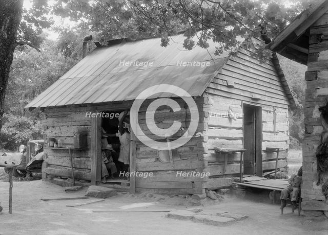 Double log cabin of Negro share tenants who raise tobacco, Person County, North Carolina, 1939. Creator: Dorothea Lange.