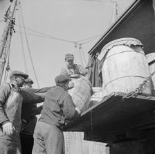 Dock worker at the Fulton fish market loading fish that have been caught..., New York, 1943. Creator: Gordon Parks
