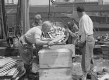 Dock stevedores packing and icing fish at the Fulton fish market, New York, 1943. Creator: Gordon Parks