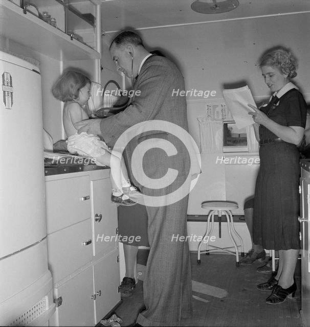Doctor examining children in trailer clinic, FSA mobile camp, Klamath County, Oregon, 1939 Creator: Dorothea Lange.