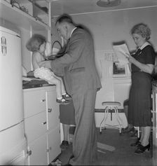 Doctor examining children in trailer clinic, FSA mobile camp, Klamath County, Oregon, 1939 Creator: Dorothea Lange
