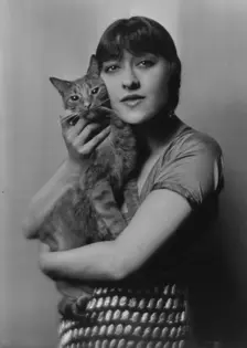 Dolly sister, with Buzzer the cat, portrait photograph, 1916. Creator: Arnold Genthe