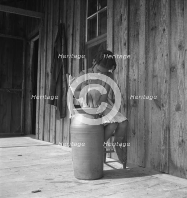 Daughter of Negro tenant churning butter. Randolph County, North Carolina, 1939. Creator: Dorothea Lange.