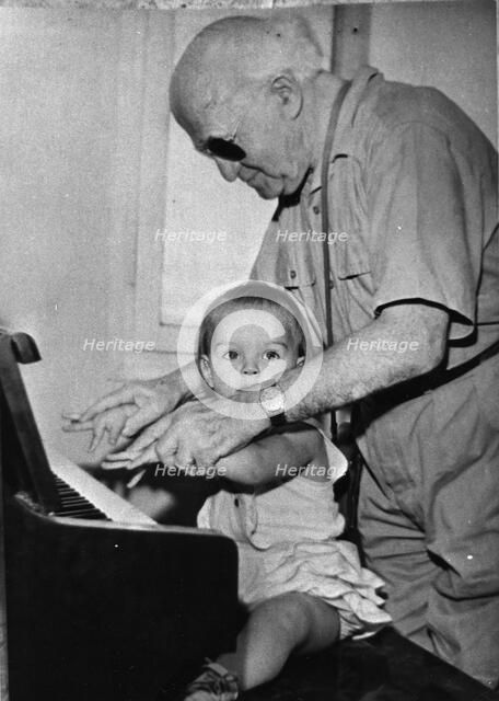 David Ben Gurion (1886-1973) trying to teach piano to his little granddaughter. Artist: Unknown