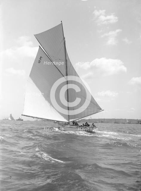 'Davo III', a 12 Metre class sailing yacht, runs before the wind, 1911. Creator: Kirk & Sons of Cowes.
