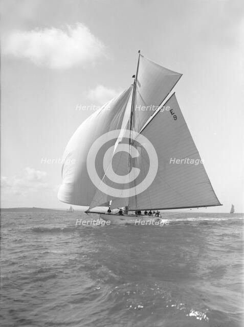 'Davo III', a 12 Metre class sailing yacht, runs before the wind, 1911. Creator: Kirk & Sons of Cowes.