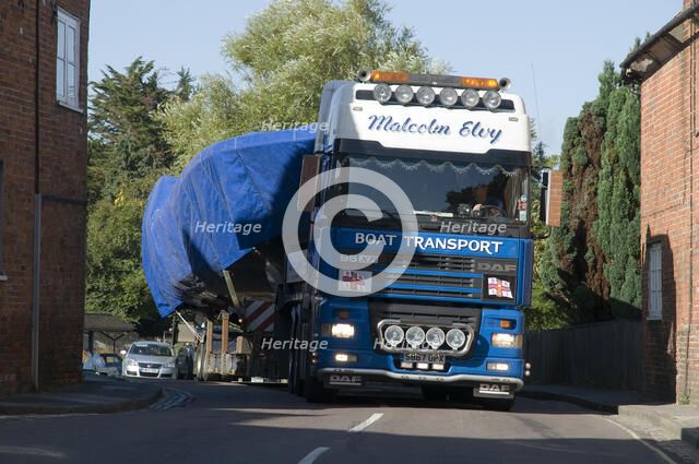 DAF 95 XF wide load truck carrying a life boat through a small village