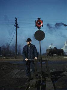 Daniel Senise throwing a switch while at work in an Indiana Harbor Belt Line railroad yard, 1943. Creator: Jack Delano