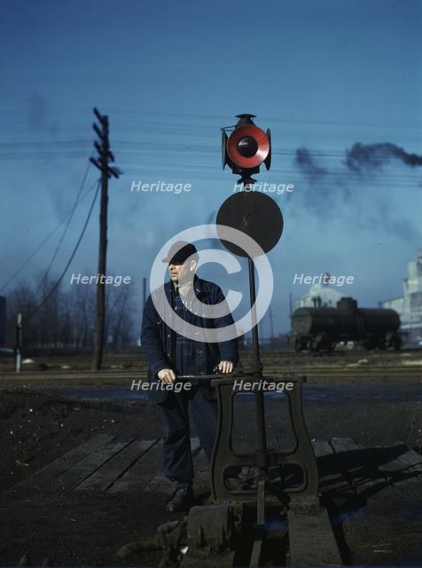 Daniel Senise throwing a switch while at work in an Indiana Harbor Belt Line railroad yard, 1943. Creator: Jack Delano.