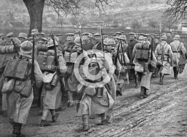 'Dans la Bataille; Une releve d'infanterie qui monte en ligne se croise avec un convoi..., 1918. Creator: Unknown.