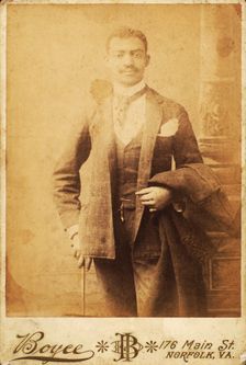 Dapper man, coat draped over his arm, and cane in hand, c1880-c1889. Creator: Unknown